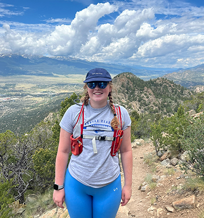 Maggie smiling in front of mountains