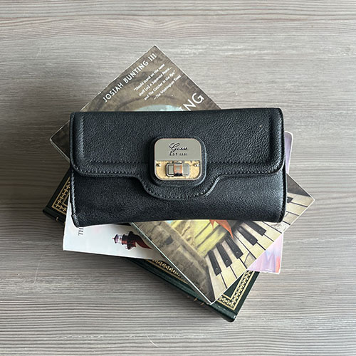 Black wallet on top of a stack of books